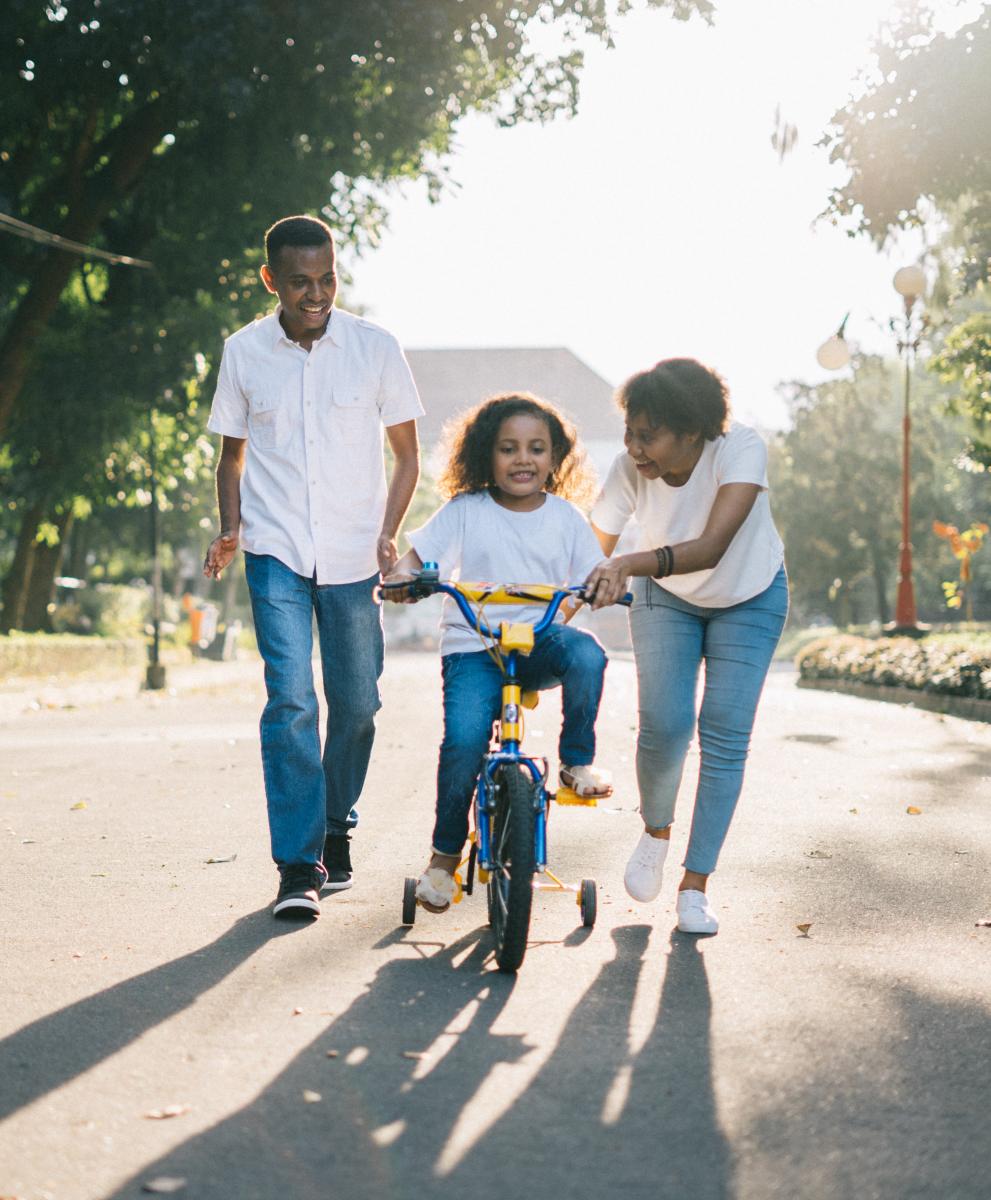 Family teaches child to ride bike