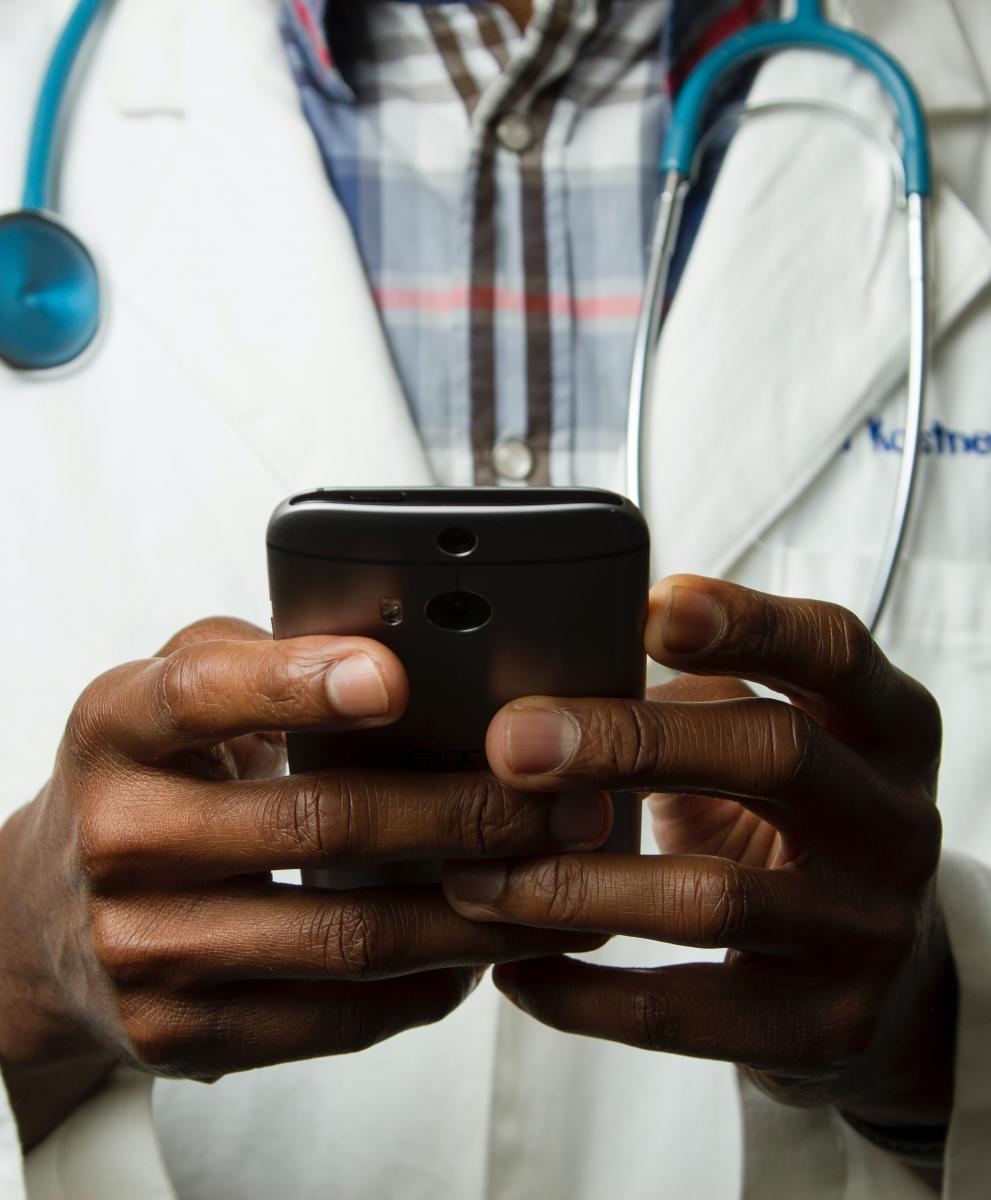 Hands of a health worker on a phone