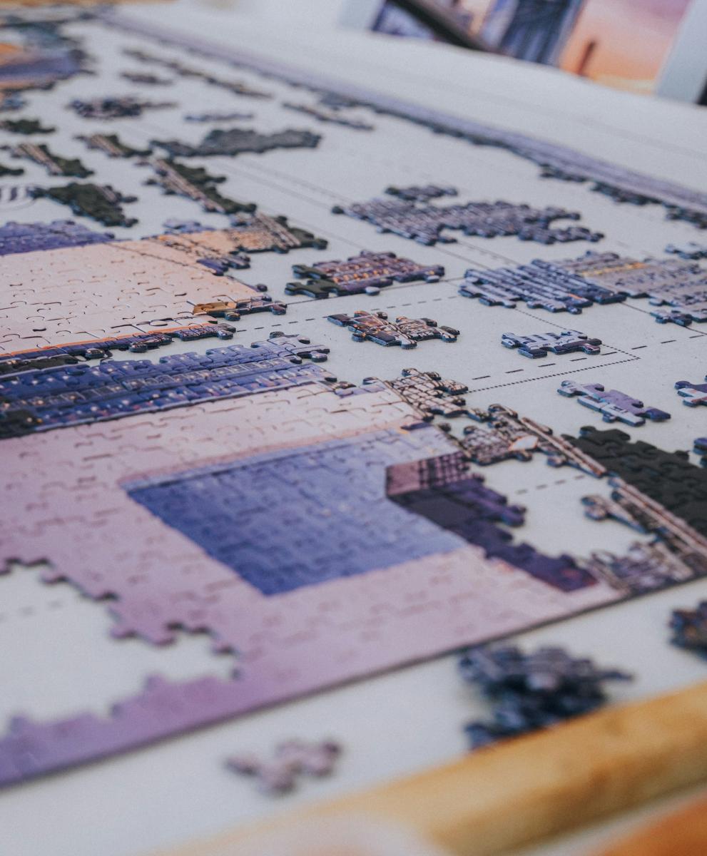 Image of a table with a semi-complete puzzle. This image represents connecting pieces. 